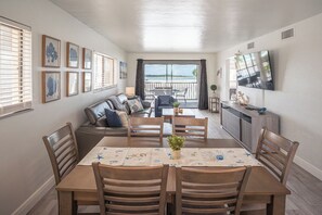 A dining area with a table, chairs, and a view to the outside. - SUMMER DISCOUNT! Beachfront 2B/2B Vacation Condo Carlos Pointe 221. Amazing Views! EVERYTHING BRAND NEW! (Fort Myers Beach)