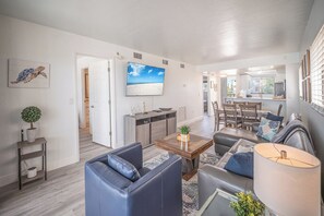 A modern living room with a sofa, coffee table, and TV. - SUMMER DISCOUNT! Beachfront 2B/2B Vacation Condo Carlos Pointe 221. Amazing Views! EVERYTHING BRAND NEW! (Fort Myers Beach)