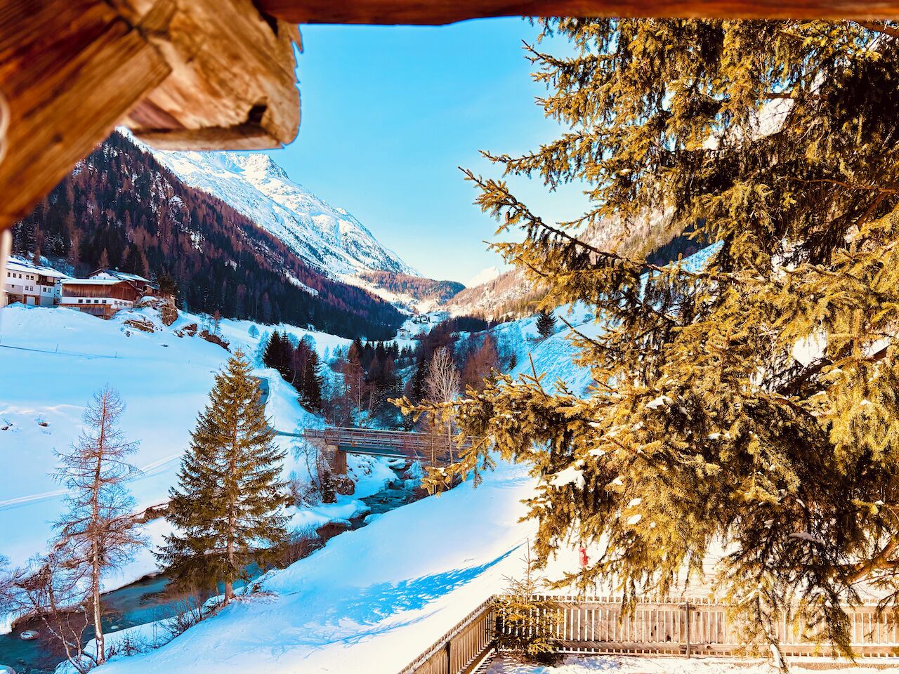 A snowy mountain landscape with a cabin and a river.