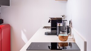 Eine moderne Küche mit Einbauherd, einer Kaffeemaschine und Holzregalen.