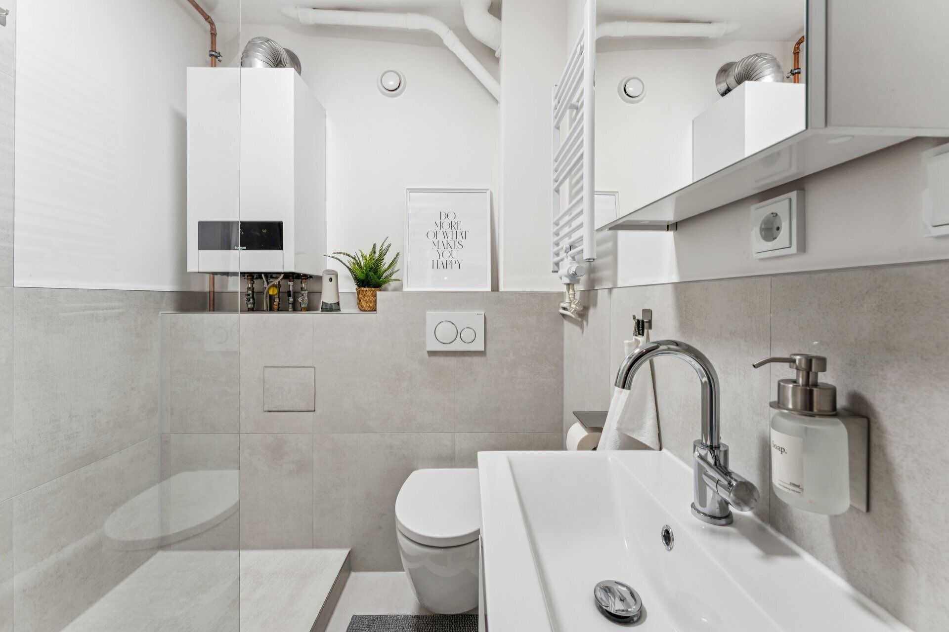 A modern bathroom with a toilet, sink, and shower.
