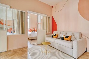 Ein modernes Wohnzimmer mit einer Couch, einem kleinen runden Tisch und einem großen Spiegel.