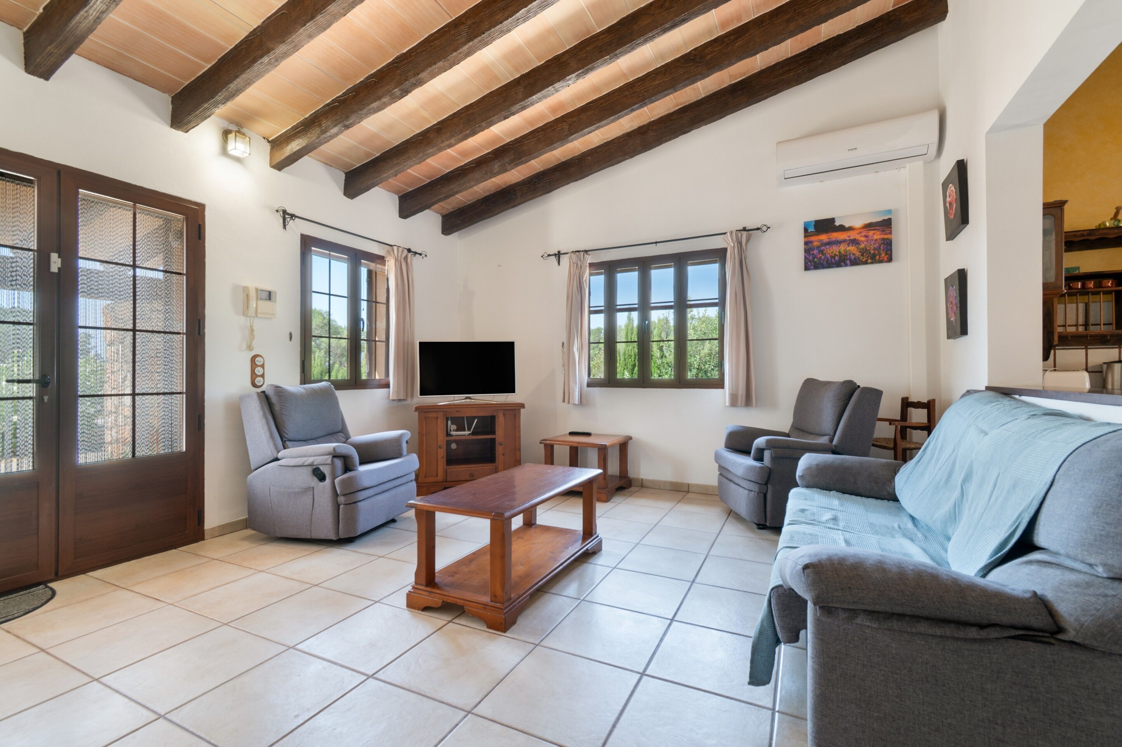A living room with a TV, two sofas, a coffee table, and a wooden cabinet.