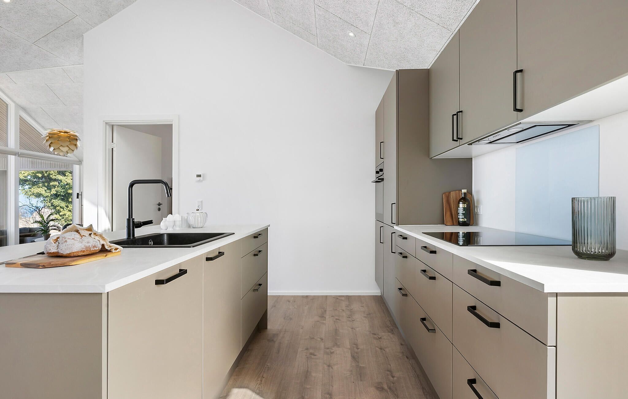 A modern kitchen with a central island, white cabinetry, and a view into the adjacent dining area.