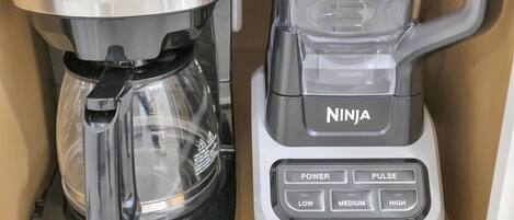 Une machine à café et un mixeur dans un placard de cuisine.