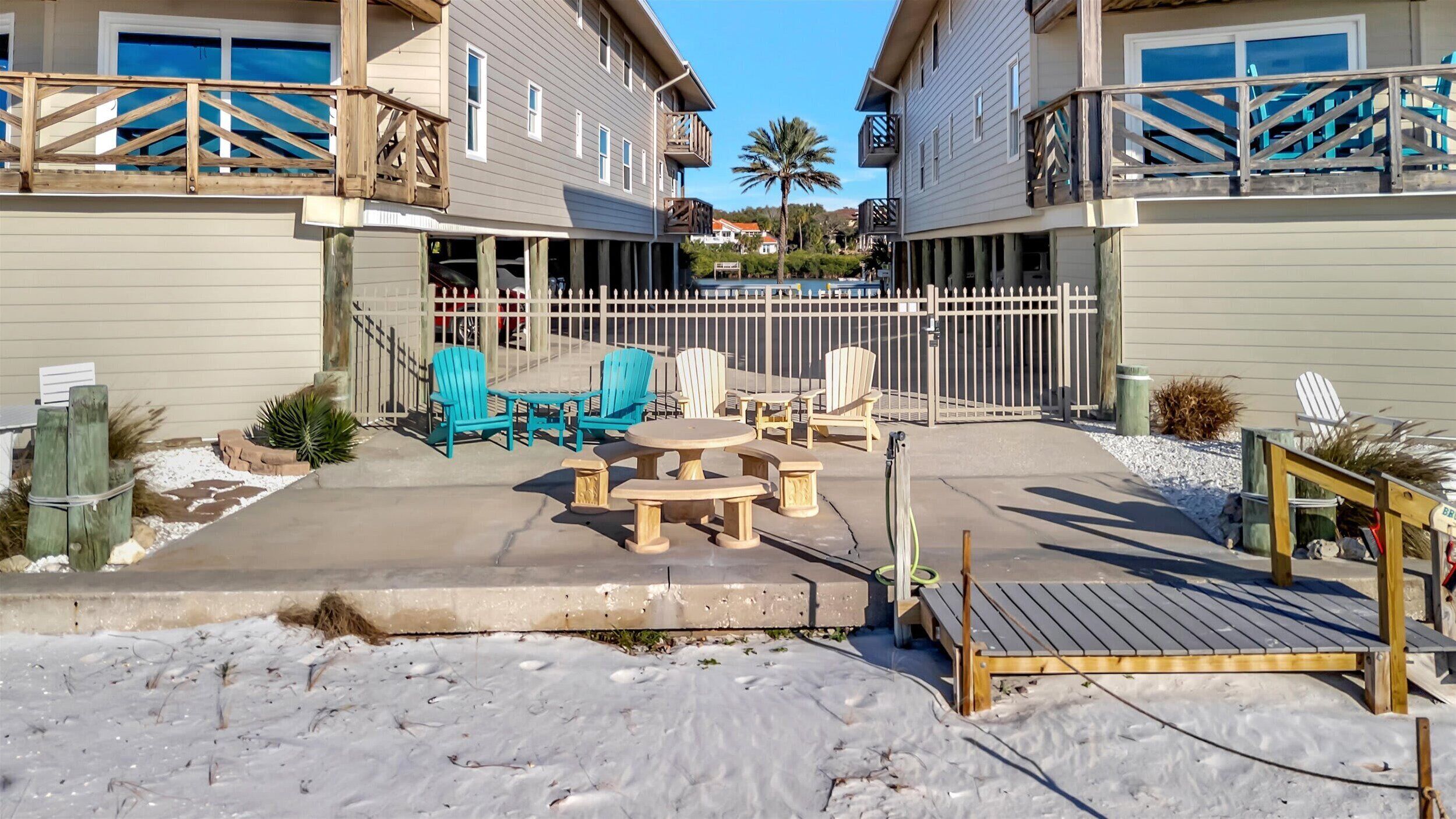 A residential building with a covered patio area featuring outdoor furniture and a wooden deck.