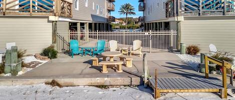 A residential building with a covered patio area featuring outdoor furniture and a wooden deck.