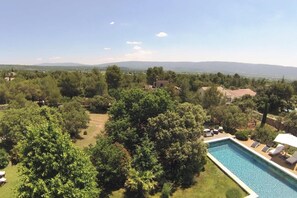 A pool with lounge chairs and a view of a mountainous landscape. - La Villa des Restanques (Cabrieres-d'Avignon)