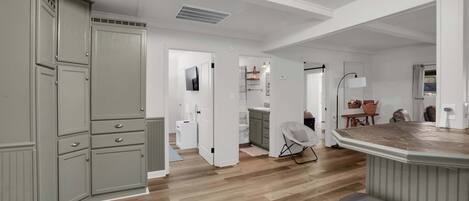 A spacious kitchen with wooden flooring, a built-in island, and grey cabinetry.