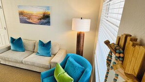 A living room with a beige sofa, blue armchair, and a lamp. - Sunny St. Pete ☀️ 2 King Beds 🛌 Close to Downtown & Beaches (St. Petersburg)