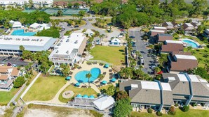 Eine Vogelperspektive des Fripp Island Beach Club mit einem großen Pool, mehreren Gebäuden und dichter Bepflanzung.