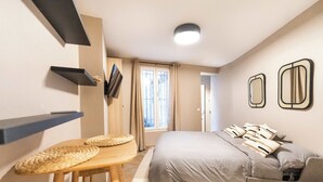 A bedroom with a bed, a desk, a chair, and a window. - Cosy et climatisé au coeur de Paris (Paris)