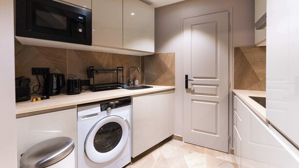 A compact kitchen with a microwave, coffee maker, and washing machine. - Cosy et climatisé au coeur de Paris (Paris)