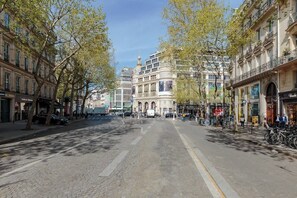 Eine Kopfsteinpflasterstraße gesäumt von historischen Gebäuden, mit einer Straßenbahn und Fahrrädern.