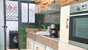 A kitchen with a washing machine, a coffee maker, and a microwave. - Prestige Apartment Centre Agdal Rabat (Rabat)