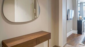 A modern hallway with a wooden console table and a large mirror. - Modern apartment with AC in the heart of the 7th arrondissement (Paris)