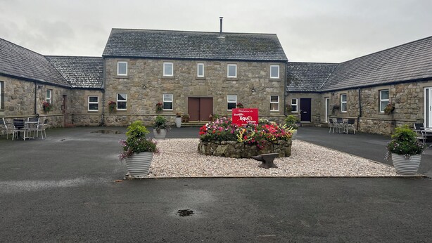 Un edificio de piedra con un cartel que dice 'Welcome to Scottish Equi Complex'.