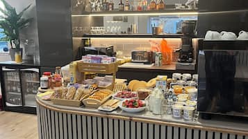 Zona de buffet con diversas opciones de comida y una estación de café.