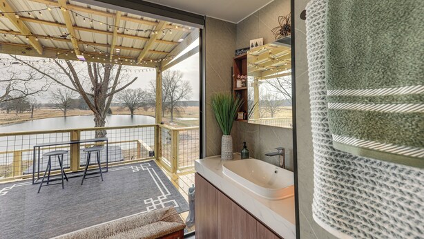 Une salle de bain moderne avec un grand miroir, un lavabo et une vue sur un lac.