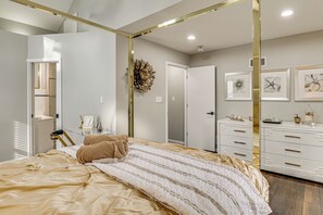 Ein Schlafzimmer mit Bett, Kommode und Spiegel.