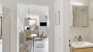 Una cocina moderna con comedor, un espejo grande y un lavamanos blanco.
