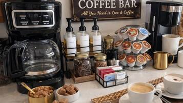A coffee bar setup with a coffee maker, jars of condiments, and a sign that reads "Gourmet Coffee Bar."