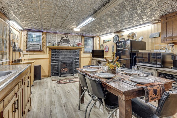 Una cocina rústica con chimenea, armarios de madera y una zona de comedor para cuatro personas.