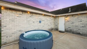 A backyard with a hot tub, a brick wall, and a door. - Hot Tub! Dog-friendly Gem 6 Mi to Dtwn Brownsville (Brownsville)