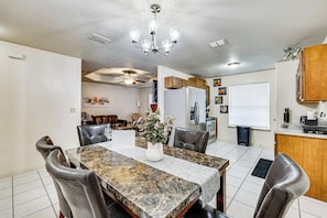 A dining area with a marble table, leather chairs, and a chandelier. - Hot Tub! Dog-friendly Gem 6 Mi to Dtwn Brownsville (Brownsville)