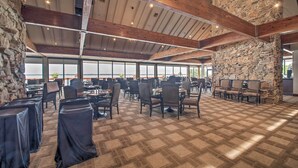A spacious indoor area with high ceilings, stone pillars, and numerous tables and chairs arranged for dining or meetings. - Golf, Swim & Dine! Condo w/ Lake Conroe Access (Montgomery)