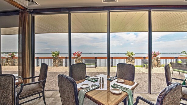 A dining area with a table set for four, large windows, and a view of the sea. - Golf, Swim & Dine! Condo w/ Lake Conroe Access (Montgomery)