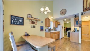 A kitchen with wooden cabinets, a wooden dining table, and a bench. There is a chalkboard with animal illustrations on the wall. - Family Nature Escape! South Branch Haven w/ Deck (South Branch)