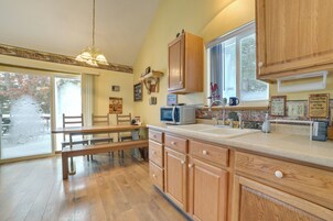 Una cocina con armarios de madera, un microondas y un fregadero.