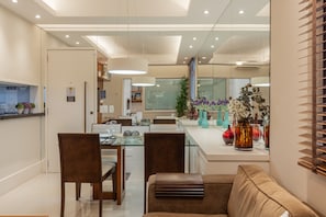 A modern dining area with a glass table, wooden chairs, and a central island with decorative vases. - 8 minutes from Ipanema beach | NS204 (Rio de Janeiro)