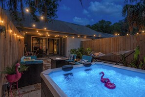 An outdoor hot tub area with seating and a wooden fence. - Chic Townhouse w/ Hot Tub, 4 Mi to Atlantic Beach! (Atlantic Beach)