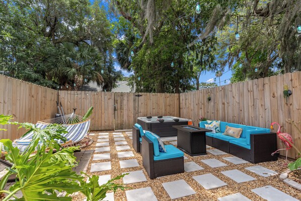 A backyard with a wooden fence, outdoor furniture, and a hammock. - Chic Townhouse w/ Hot Tub, 4 Mi to Atlantic Beach! (Atlantic Beach)