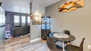 A modern living room with a sofa, a dining table with chairs, and a decorative wall piece. - Easily Explore Anchorage! Modern Duplex Near Town (Anchorage)