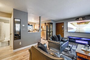 A modern living room with a leather sofa, a coffee table, and a flat-screen TV. - Easily Explore Anchorage! Modern Duplex Near Town (Anchorage)