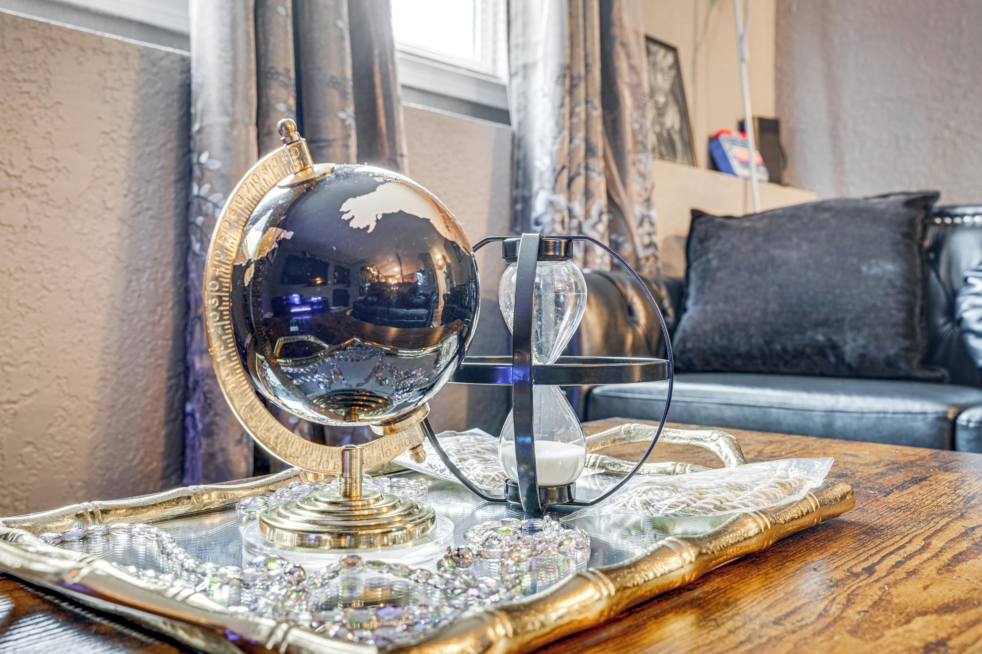 Una bandeja decorativa con un globo de cristal y un candelabro sobre una mesa de madera.