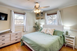 A bedroom with a bed, nightstands, a TV, and a ceiling fan. - Musicians Beachside Retreat in Lake in the Hills (Lake in the Hills)