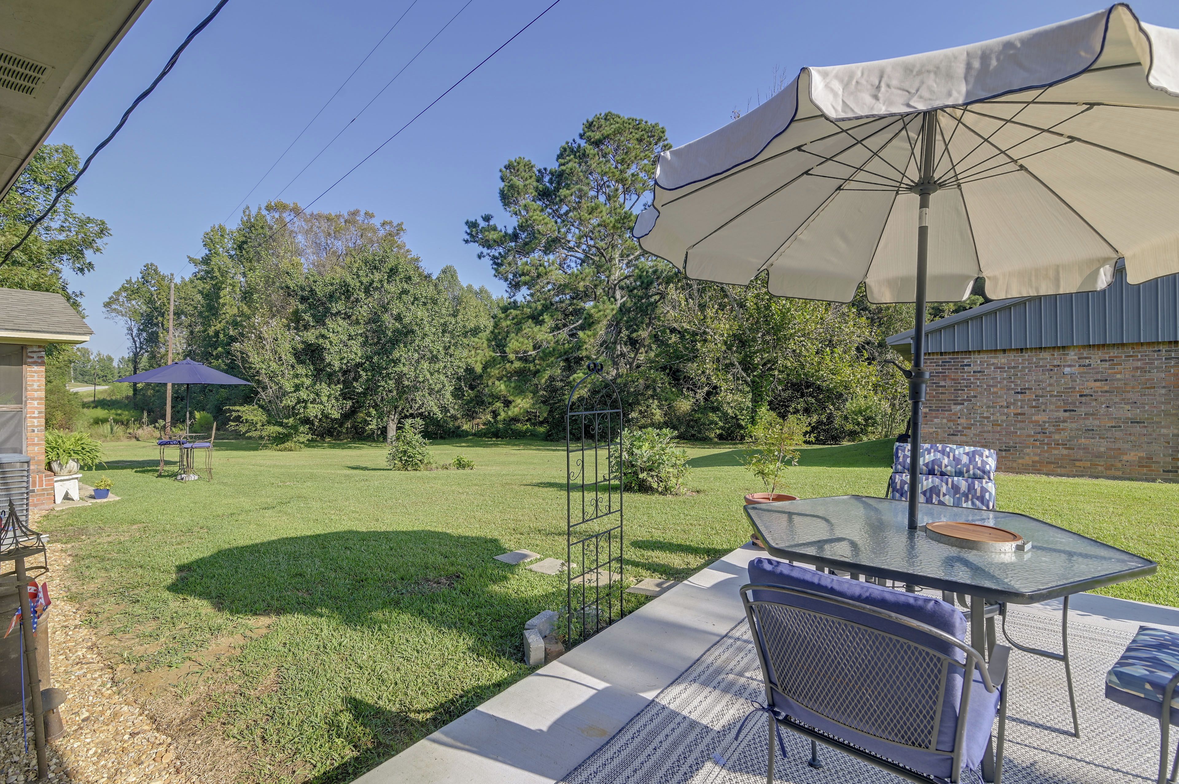 A patio area with a table, chairs, and an umbrella.