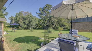 A patio area with a table, chairs, and an umbrella.