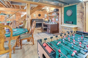 Una habitación acogedora con mesa de fútbol de mesa, dardos y un piano.