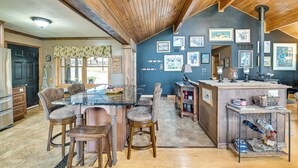 A kitchen with a wooden ceiling, a marble countertop, and a dining area with four chairs. - Beautiful & Unique Farmhouse 15 Mi to Saratoga (Fort Edward)