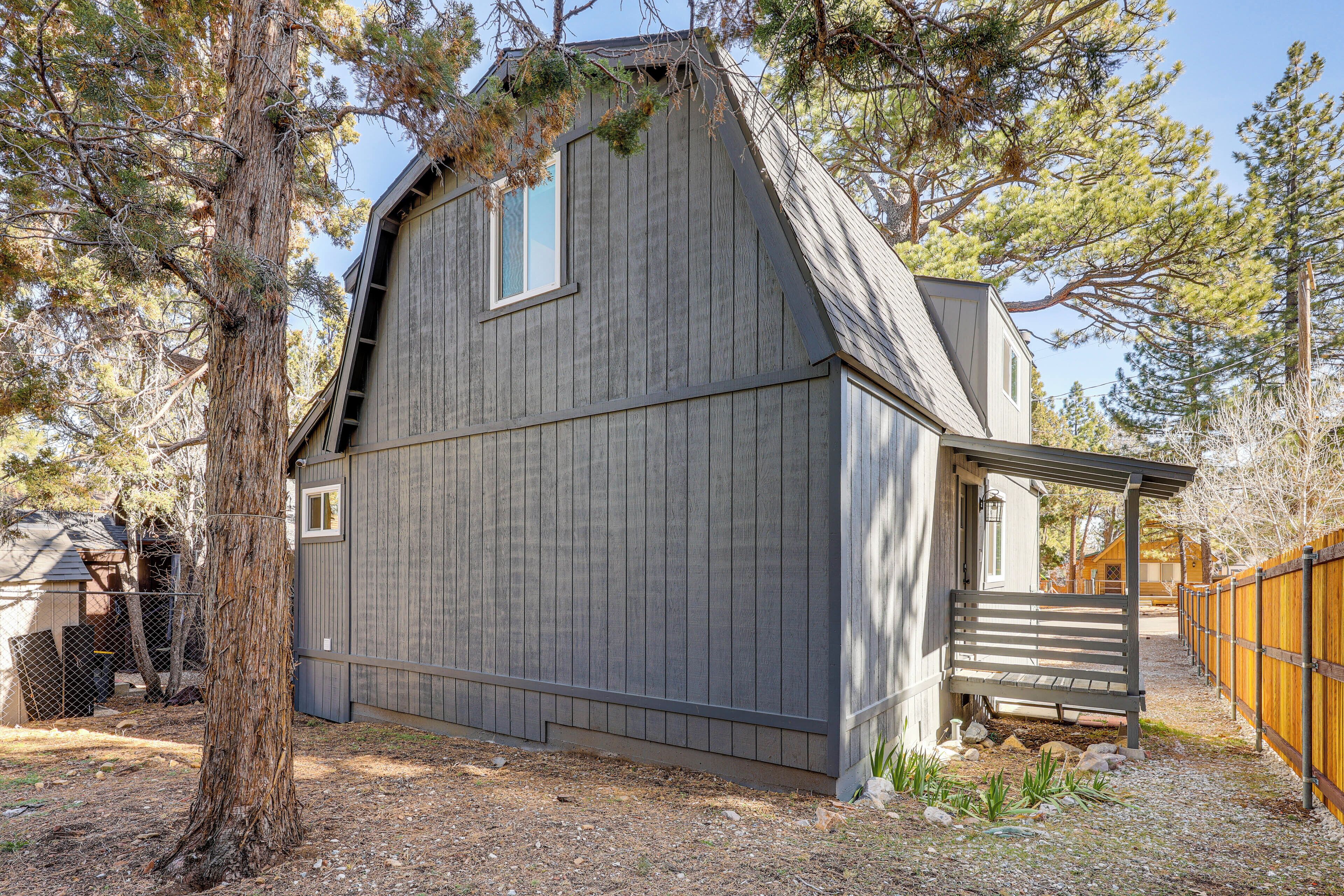 A single-story house with a sloped roof, a covered porch, and a fenced yard.