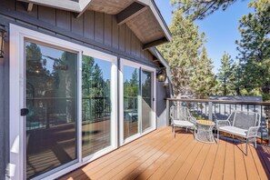 A wooden deck with sliding glass doors, outdoor furniture, and a view of the surrounding trees. - 5 Mi to Lake & Skiing! All-season Big Bear Base (Sugarloaf)