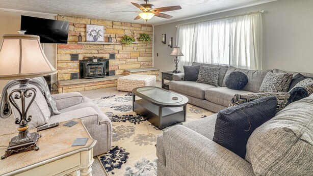 A living room with a fireplace, a ceiling fan, and a large window with curtains. - 1/2 Mi to Kanawha River: Quiet Escape w/ Patio (Belle)