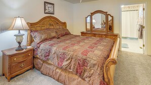 A bedroom with a wooden bed, a nightstand with a lamp, a dresser, and a mirror. - 1/2 Mi to Kanawha River: Quiet Escape w/ Patio (Belle)