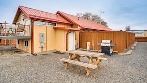 A two-story building with a red roof, a wooden deck, and a barbecue grill in the backyard. - Walk to Main Ave & Soap Lake! Pet-friendly Studio (Soap Lake)