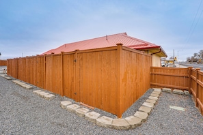 A wooden building with a red roof, a gravel driveway, and a wooden fence. - Walk to Main Ave & Soap Lake! Pet-friendly Studio (Soap Lake)